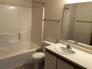 Fargo apartment for rent - A white toilet sits next to a white sink in a small bathroom.