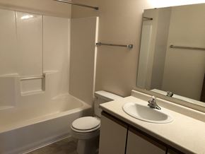 Fargo apartment for rent - A white toilet sits next to a white sink in a small bathroom.