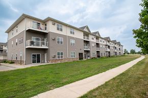Fargo apartment for rent - a large apartment complex with a grassy area in front of it at Boulder Ridge Apartments, Fargo