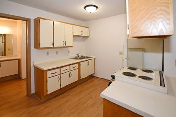 Hudson apartment for rent - a kitchen with white cabinets and a stove and a sink