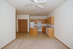 Clearwater apartment for rent - an empty kitchen with a ceiling fan and wooden cabinets at Cedar Ridge Apartments, Clearwater, 55320
