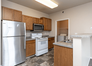 Moorhead apartment for rent - A kitchen with a refrigerator, microwave, oven, and sink. at Courtyard Apartments on Belsly  Apartments, Moorhead, MN