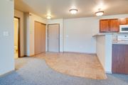 Moorhead apartment for rent - an empty living room and kitchen with a microwave and a sink at Waterstone  Apartments, Moorhead, MN