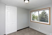 Grand Forks apartment for rent - a bedroom with a large window and a white door at Southern Manor Apartments, Grand Forks, ND