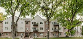 Fargo apartment for rent - A large apartment building with balconies and trees in front.