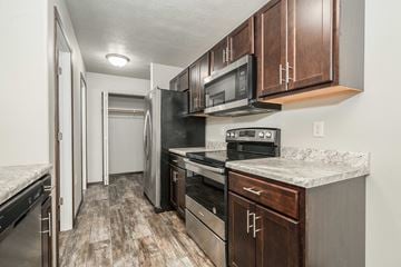 Sioux Falls townhouse for rent - a kitchen with stainless steel appliances and wooden cabinets