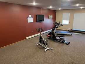 Fargo apartment for rent - a room with two exercise bikes and a flat screen tv at Bluemont Village  Apartments, Fargo, ND