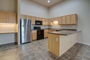 West Fargo apartment for rent - A kitchen with wooden cabinets and a granite countertop.