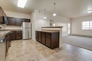 West Fargo apartment for rent - A kitchen with brown cabinets and a tiled floor.