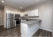 Fargo apartment for rent - A kitchen with a granite countertop and stainless steel appliances. at Warehouse Apartments, North Dakota