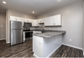 Fargo apartment for rent - A kitchen with a granite countertop and stainless steel appliances. at Warehouse Apartments, North Dakota