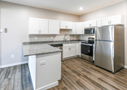 Fargo apartment for rent - A kitchen with a granite countertop and stainless steel appliances. at Warehouse Apartments, North Dakota