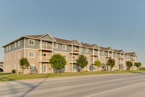 Moorhead apartment for rent - a street view of an apartment complex with a clear blue sky in the background at Waterstone Apartments, Moorhead, 56560