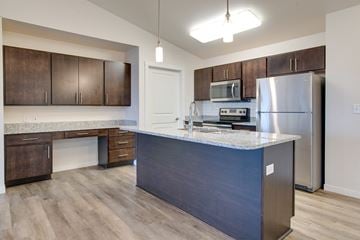 Fargo apartment for rent - a kitchen with a large island and stainless steel refrigerator