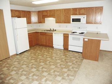 Detroit Lakes apartment for rent - A kitchen with white appliances and wooden cabinets.