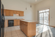 Fargo townhouse for rent - A kitchen with wooden cabinets and a black refrigerator.