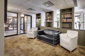 Chicago apartment for rent - a lounge area with leather couches and chairs and a book shelf