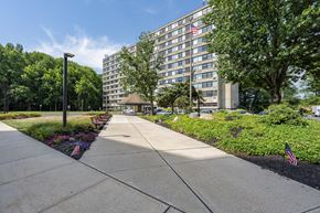 Hamilton apartment for rent - a sidewalk in front of a large building flags