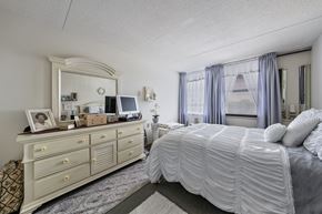 Hamilton apartment for rent - a bedroom with a large bed and a dresser with a mirror