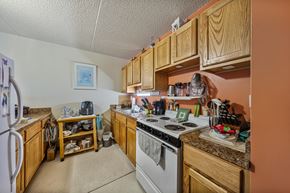 Hamilton apartment for rent - a kitchen with wood cabinets and white appliances and a stove top oven