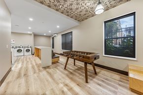 Jersey City apartment for rent - a game room with a foosball table and a large window