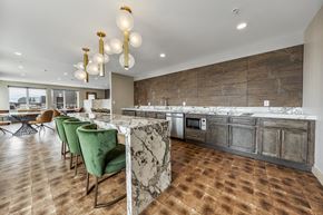 Jersey City apartment for rent - a large kitchen with marble counter tops and green chairs