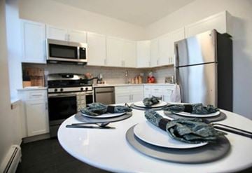 Hoboken apartment for rent - A kitchen with a white table and black plates.