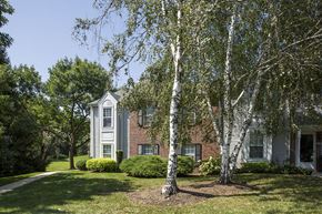 Phoenixville apartment for rent - Exterior of Westridge Gardens with tall tress, freshly cut grass, and a walking path