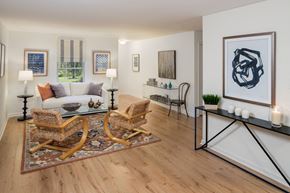 Phoenixville apartment for rent - Furnished living room with a white couch and two wicker chairs sitting on top of an area rug
