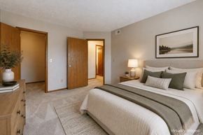 Columbus apartment for rent - A bedroom with a large bed and a painting on the wall.