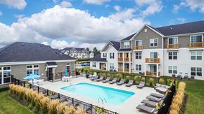 Hilliard apartment for rent - a swimming pool with lounge chairs in front of apartment buildings