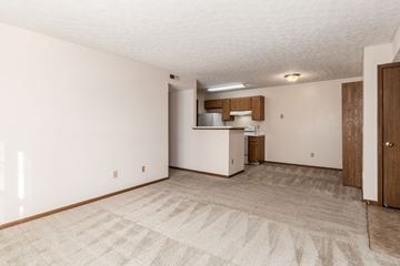 Powell apartment for rent - A room with a carpeted floor and a small kitchenette.