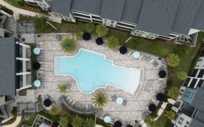 Newberry apartment for rent - A swimming pool surrounded by a stone patio and umbrella tables.