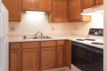 Cedar Grove apartment for rent - a kitchen with wooden cabinets and a stove and a sink