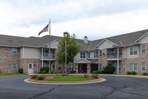 Mequon apartment for rent - a large building with an flag in front of it