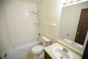 Grafton apartment for rent - A white toilet sits next to a bathtub in a bathroom.