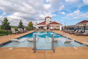 Cedarburg apartment for rent - A large outdoor pool with a diving board and lounge chairs.