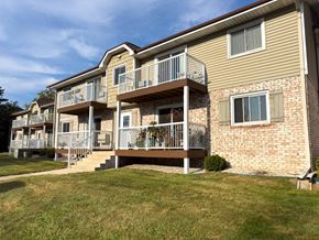 Saukville apartment for rent - A two-story apartment building with a balcony on the second floor.