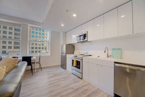 Cleveland apartment for rent - a kitchen and living room with white cabinets and a stainless steel