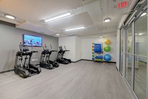 Cleveland apartment for rent - a gym with exercise equipment and a tv on the wall