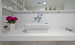 Seattle apartment for rent - a white bathroom with a sink and a vase of flowers