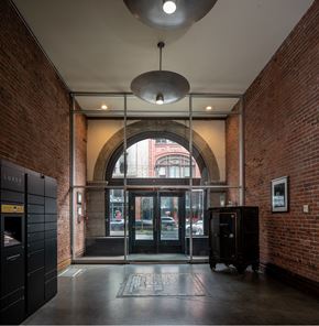 Seattle apartment for rent - a lobby with an arched door and a brick building in the background