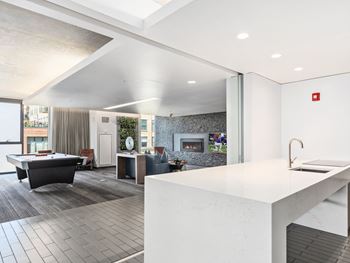 An open kitchen and living room with a pool table