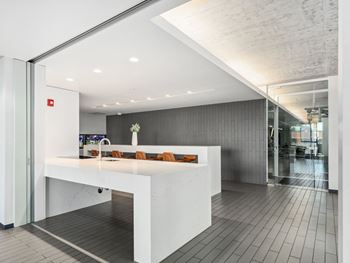 An open office area with a white counter and a glass door