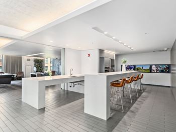 A large white kitchen with a bar and chairs