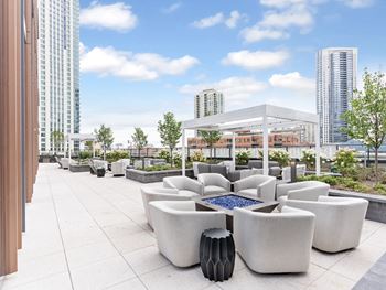 A rendering of a rooftop patio with couches and afire pit
