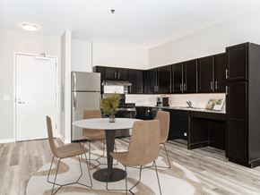 Chicago apartment for rent - a kitchen and dining area with black cabinets and a refrigerator