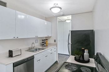 A kitchen with white cabinets and stainless steel appliances