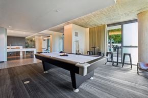 Chicago apartment for rent - A pool table is in the middle of a room with a wooden floor.