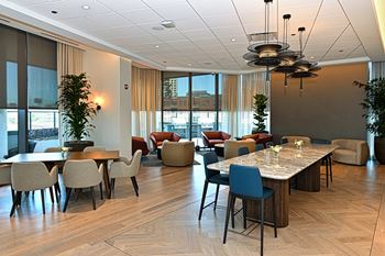 A large dining room with tables and chairs and large windows